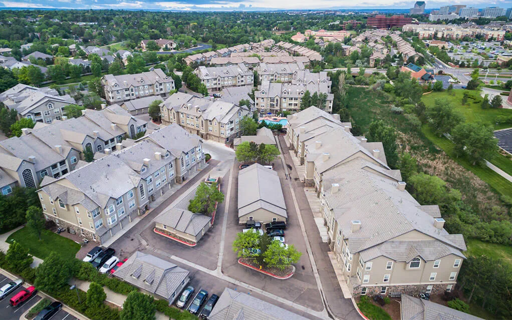 Overhead aerial view of a modest apartment complex during the afternoon of a partly cloudy day