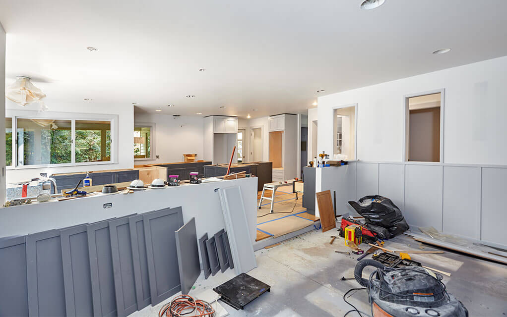 View from the living room into the kitchen of an upscale middle-class home that is undergoing a major renovation in the living room and the kitchen