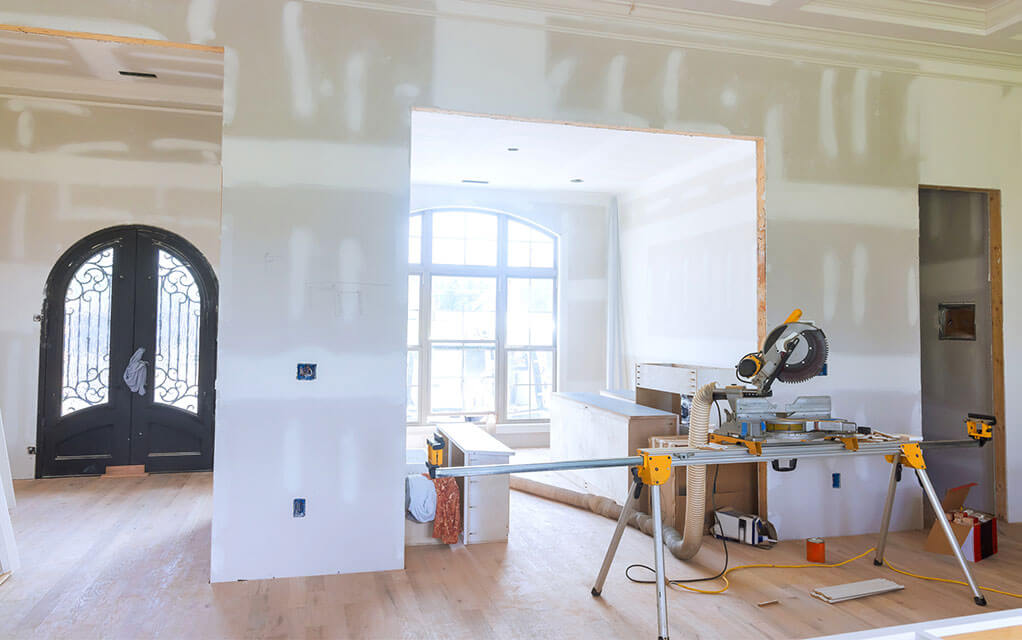 The walls of a upscale home are ready for painting as construction tools and materials lay waiting in the foreground to be used