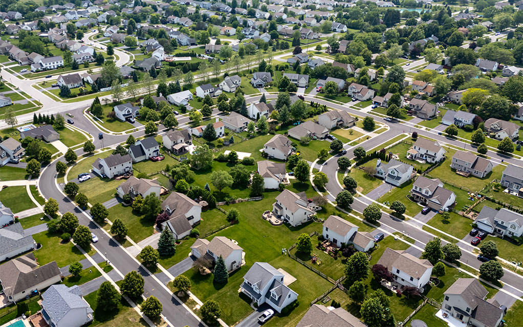 Aerial view of a sprawling suburban neighborhood on a bright and sunny day