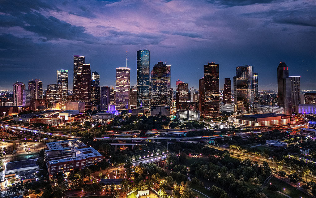 View of downtown Houston, TX lit up at night on a cloudy night