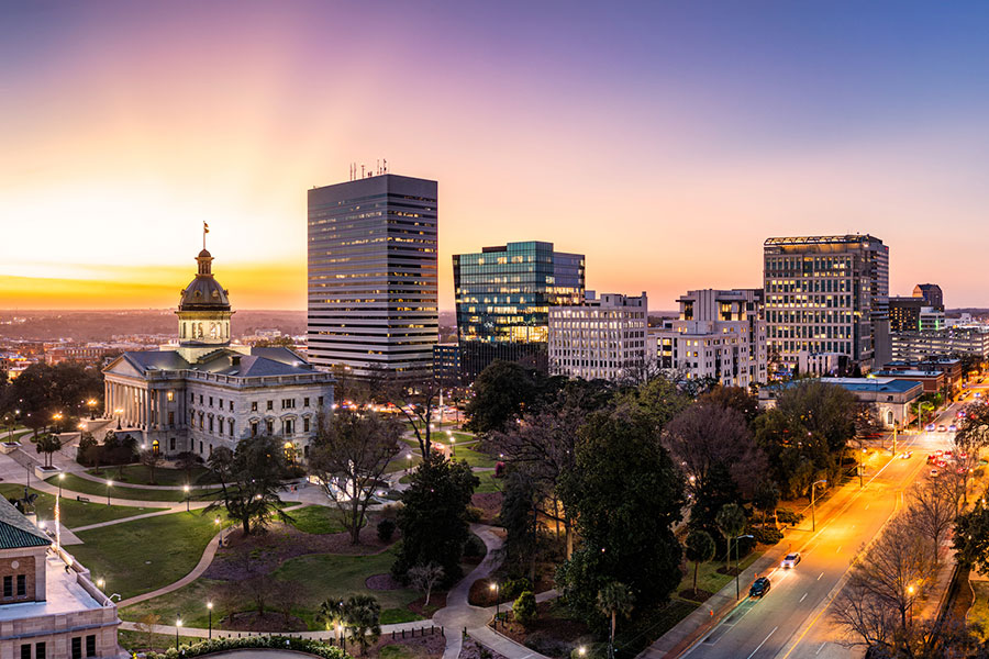A view of the South Carolina State Capitol building and downtown Columbia, SC as the sun goes down at twilight.