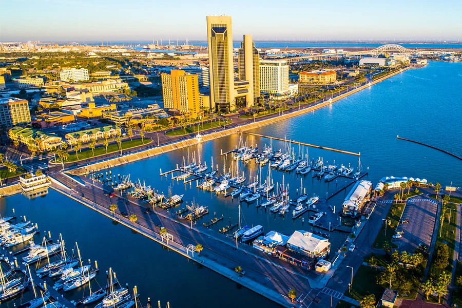 An aerial view of Bayfront, the Twin Towers, and the Harbor Bridge in the background on a bright and sunny morning in Corpus Christi, TX