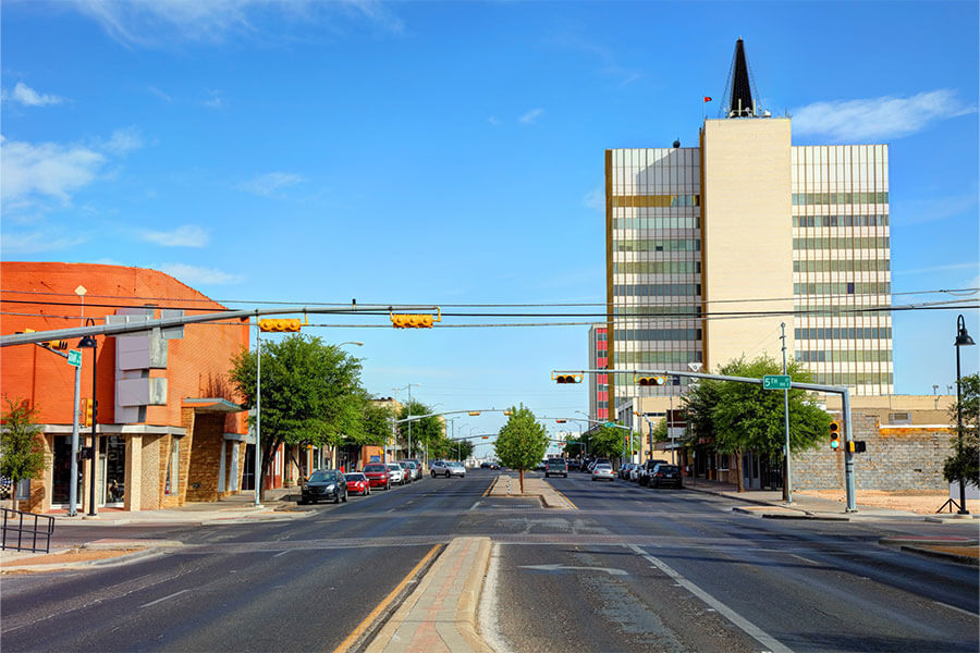 A view down a low traffic road in downtown Odessa, TX on a bright and sunny spring afternoon